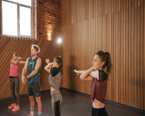Group fitness class indoors with bright artificial lighting